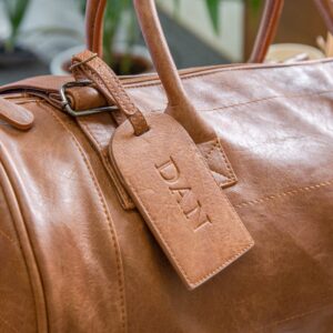 Faux Leather Barrel Bag With Luggage Tag - Duncan Stewart 1978